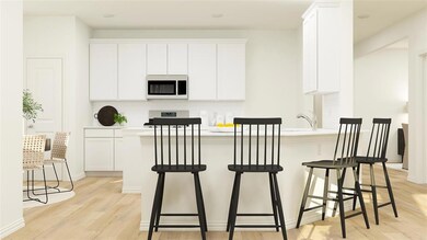 Kitchen with a kitchen bar, backsplash, white cabi