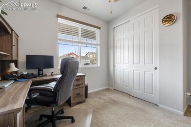 Home office featuring light carpet and ceiling fan