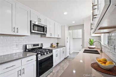 New stainless steel gas range, new microwave, dishwasher.  Kitchen leads to indoor laundry room and  1/2 bath - door to back yard in laundry room, convenient when coming in from the pool