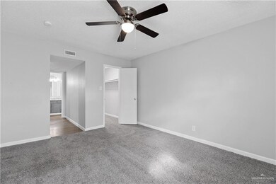 Unfurnished bedroom with a closet, a spacious closet, ceiling fan, and a textured ceiling