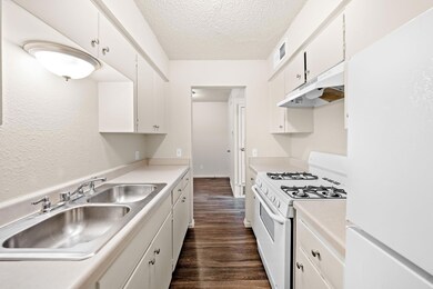 Kitchen featuring white appliances, dark wood-sty