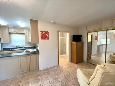 Kitchen featuring a wealth of natural light, electric range oven, sink, and light tile patterned floors