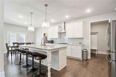Kitchen with white cabinets, a sink, tasteful back