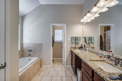 Bathroom featuring lofted ceiling, a sink, a bath,