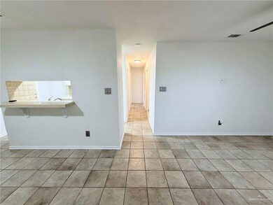 Spare room featuring light tile patterned floors and baseboards