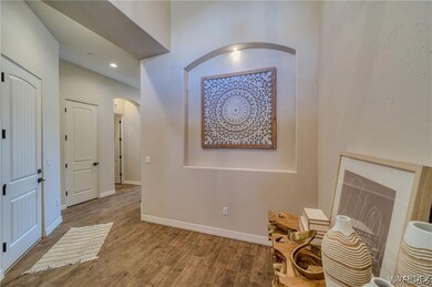 Hall with wood finished floors, arched walkways, a