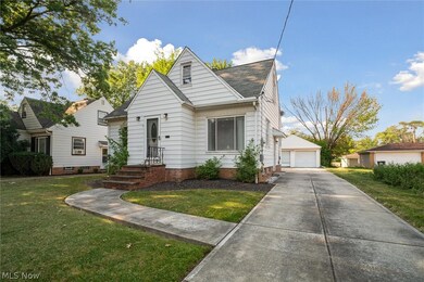 View of front of house with an outdoor structure, a garage, and a front lawn