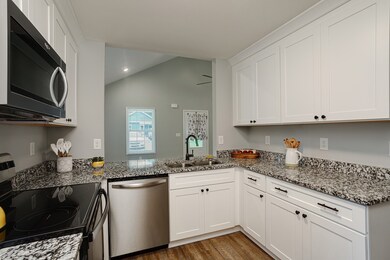 Kitchen features include real GRANITE counter tops, crisp white cabinets, built in microwave, dishwasher and smooth surface cook top.