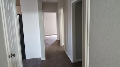 Hallway with baseboards and dark wood-style floors