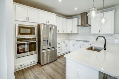 Kitchen featuring wall chimney range hood, applian