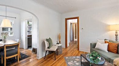 Step inside to gleaming original hardwoods, graceful arched doorways, and a light, bright atmosphere that feels instantly inviting.