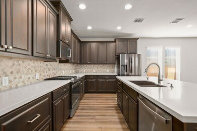 Kitchen featuring light countertops, a sink, dark