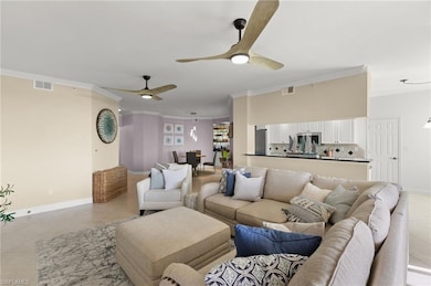 Living room featuring crown molding, light tile pa