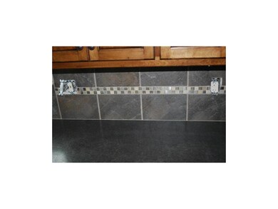 Decorative medallions at tile backsplash in kitche