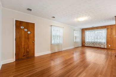Foyer with a textured ceiling, wood-type flooring,