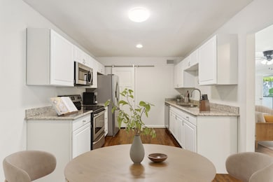 The kitchen adorns granite countertops, white cabi