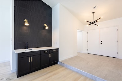 Entryway featuring a chandelier, light wood-type f