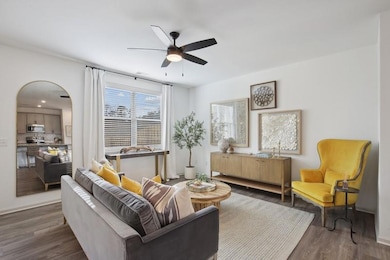 Living room with dark wood-type flooring and ceiling fan