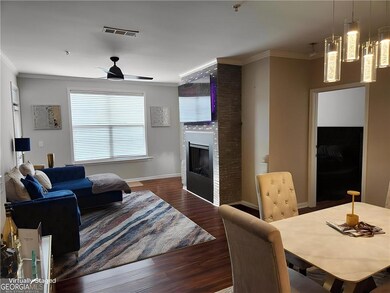 Living area with crown molding, wood finished floo