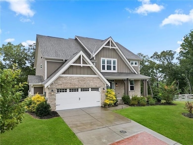 Craftsman house featuring board and batten siding, a porch, brick siding, a garage, and concrete driveway