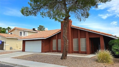 View of front facade with a chimney, a garage, con