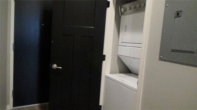 Washroom featuring stacked washer / drying machine