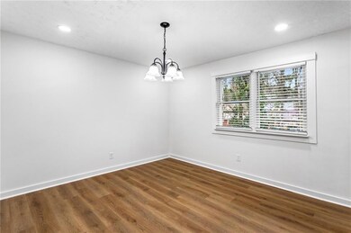 Spare room featuring wood finished floors, recessed lighting, and a chandelier