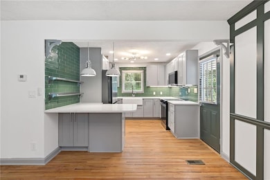 Kitchen with stainless steel microwave, light wood