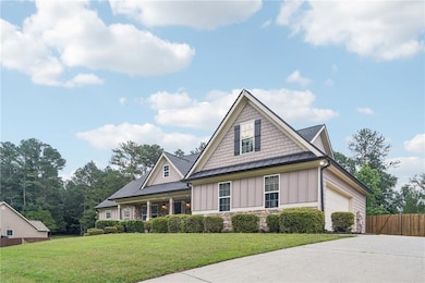 Craftsman inspired home with board and batten siding, a standing seam roof, stone siding, an attached garage, and concrete driveway