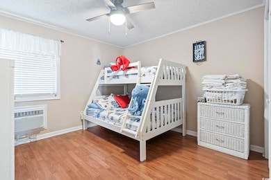Bedroom with a textured ceiling, ceiling fan, a wa