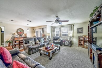 Living room featuring ceiling fan and a textured c