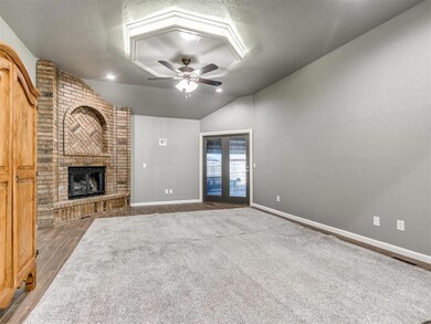 Living room with a brick fireplace, a textured cei