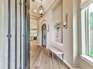 Enter thru the wrought iron embellished mahogany door to the entyy way with art niche.