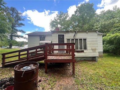 Back of property featuring a wooden deck, a chimne