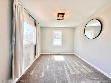 Carpeted spare room featuring baseboards