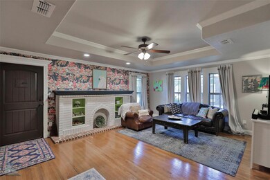 Living room featuring a brick fireplace, hardwood 