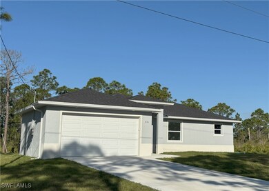 Ranch-style home with a front yard, a garage, driv