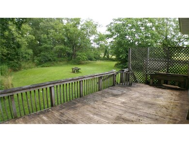 View of backyard off of large rear wood deck.