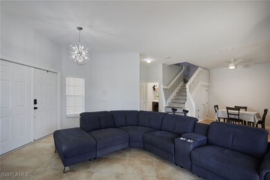 Living area featuring a chandelier, stairway, a ce