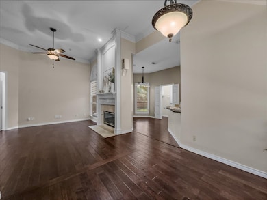 Unfurnished living room featuring crown molding, a ceiling fan, dark wood finished floors, a tiled fireplace, and recessed lighting