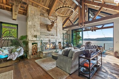 Open plan great room with captivating lake views, Montana Stone fireplace, wood trusses and T&G vaul
