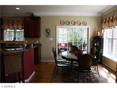 Breakfast Nook - Windows and glass doors flood the Breakfast area with light! Crown molding and wood floors  add to the charm.