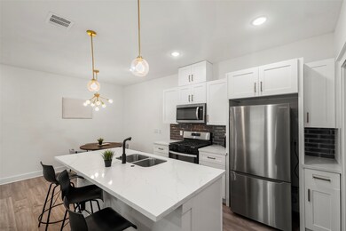 The sleek kitchen offers crisp white cabinets and