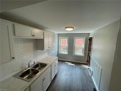 Kitchen featuring hardwood floors, backsplash, lig