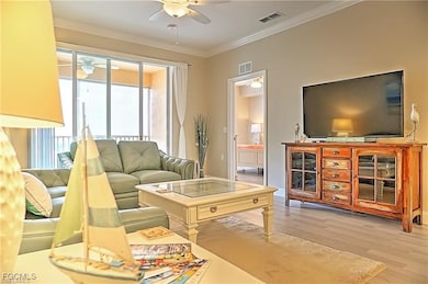 Living room with light wood-style flooring and crown molding