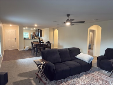 Living room with arched walkways, a ceiling fan, 