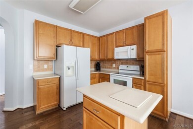 The kitchen has wood cabinetry, plenty of counter