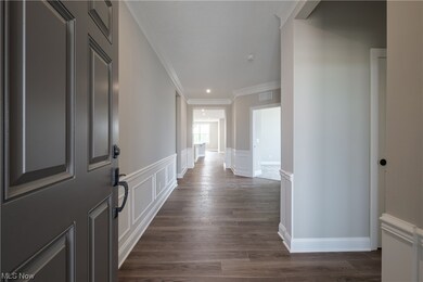 Corridor featuring crown molding and dark hardwood floors