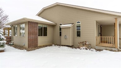 Side of condo showing the 4 season room and brick accents on the exterior