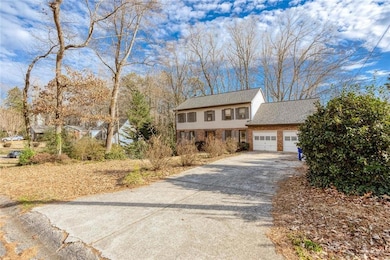 View of front facade featuring a garage, concrete driveway, and brick siding